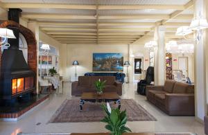 sala de estar con sofá y chimenea en Hotel Galo Vermelho, en Gramado