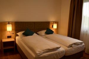 ein Hotelzimmer mit 2 Betten und 2 Lampen in der Unterkunft Gasthof Kranerwirt in Lannach