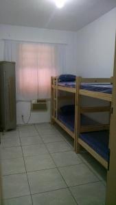 a room with two bunk beds and a window at Pousada Casa 6 in São Vicente