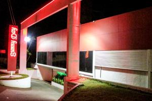 una gasolinera por la noche con luces rojas en Motel Sunny Day BH, en Belo Horizonte