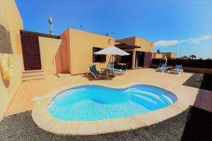 a swimming pool in the middle of a yard at Fuerteventura Sol Deluxe Villas in La Oliva