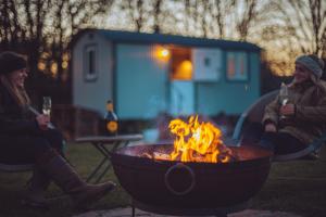 a group of people sitting around a fire pit at Shabby Shepherds in Penrith