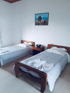 a bedroom with two beds and a picture on the wall at Katerina Studios in Laganas