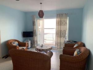 a living room with chairs and a table and a window at Well equipped peaceful 3 bedroom apartment in Flic-en-Flac