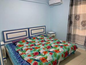 Un dormitorio con una cama con un edredón de flores. en Well equipped peaceful 3 bedroom apartment, en Flic en Flac