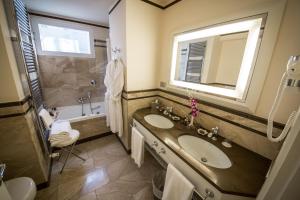 a bathroom with a sink and a tub and a mirror at Victoria Hotel Letterario in Trieste