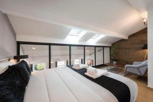 ein Schlafzimmer mit einem großen weißen Bett und einem Fenster in der Unterkunft Modern Loft with AC in Downtown Porto by LovelyStay in Porto