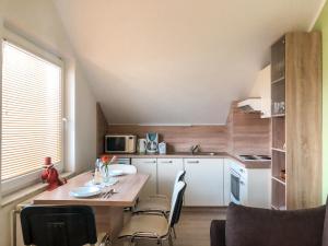 una pequeña cocina con mesa de madera y sillas en Apartments Sončnica, en Moravske Toplice