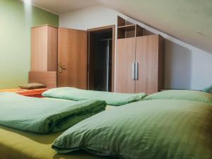 Duas camas com edredões verdes num quarto em Apartments Sončnica em Moravske Toplice
