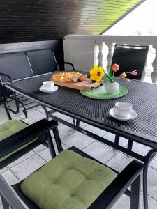 una mesa con una bandeja de comida y flores. en Apartments Sončnica, en Moravske Toplice