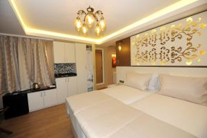 イスタンブールにあるRooms Inn Taximのベッドルーム1室(白いベッド2台、シャンデリア付)