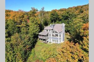 an aerial view of a large house in the forest at Ski-in/Car-out, HOT TUB with Amazing sunset view in Saint-Faustin