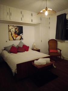 a bedroom with a large bed and a chair at Chambre Marguerite, B&B au 1er- Villa Chaumonty in Périgueux