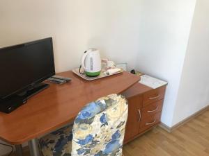 a wooden desk with a computer monitor and a chair at Pink Inn in Podstrana