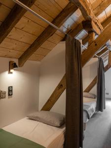 two beds in a loft bedroom with wooden ceilings at AUBERGE BORDA in Saint-Michel