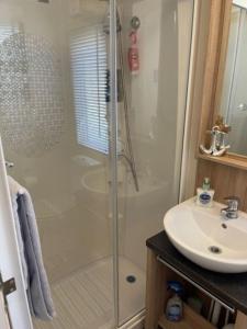 a bathroom with a shower and a sink at Beautiful Spacious Holiday Home - Romney Sands in New Romney