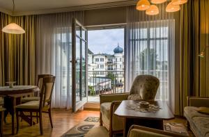 a living room with a couch and a table and a large window at Hotel Meereswelle - Anno 1875 in Ahlbeck