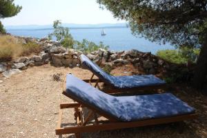 two lounge chairs with a view of the water at A small stone house by the sea, in a wineyard in Nerežišća