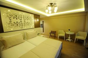 1 dormitorio con 1 cama blanca, mesa y sillas en Rooms Inn Taxim, en Estambul