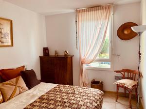 een slaapkamer met een bed en een raam bij Le Saint Loup (terrasse et parking) in La Ciotat