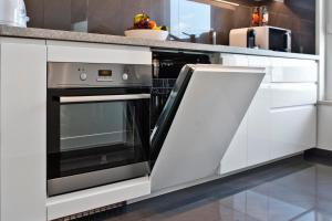 a kitchen with an oven in a white kitchen at P&O Serviced Apartments Nowy Ursus in Warsaw