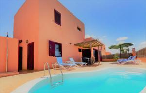 una casa con piscina accanto a un edificio di Fuerteventura Sol Deluxe Villas a La Oliva