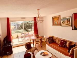 een woonkamer met een bank en een tafel bij Le Saint Loup (terrasse et parking) in La Ciotat