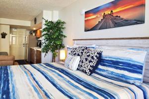 a bedroom with a blue and white bed with pillows at Pirates Cove Condo Unit #704 in Daytona Beach Shores