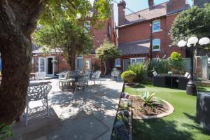 a patio with tables and chairs in a yard at Somerset House Boutique Hotel and Restaurant in Portsmouth