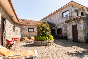 a stone building with chairs and a patio at Leira da Cruz Grande in Castelo de Paiva