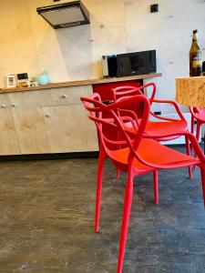 dwa czerwone krzesła w kuchni z blatem w obiekcie Góra Jabłek Mazury Mikolajki w mieście Lipowo