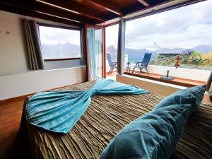 een groot bed in een kamer met een groot raam bij La Morada in Artenara