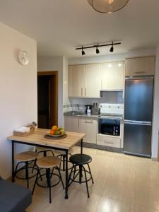 uma cozinha com mesa e cadeiras e uma cozinha com frigorífico em Luky Miño em Miño