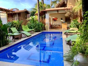 傑里科科拉的住宿－Pousada CasAlice，一个带绿色椅子的游泳池