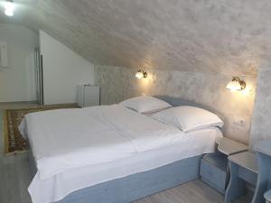 Ένα ή περισσότερα κρεβάτια σε δωμάτιο στο Pensiunea Antonia