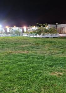 a white fence in a field at night at Al Moltaqua Chalet in Taif