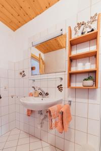 ein Bad mit einem Waschbecken und einem Spiegel in der Unterkunft Haus Netzer in Bartholomäberg