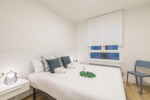 1 dormitorio blanco con 1 cama y 1 silla azul en Egia Plaza, en San Sebastián