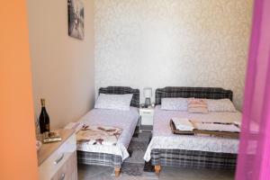 two beds in a small room with pink walls at Aпартаменты Влаович in Igalo
