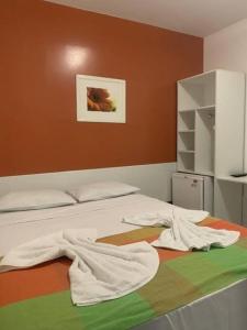 een slaapkamer met een bed met handdoeken erop bij Pousada Ilha Bela in Maceió