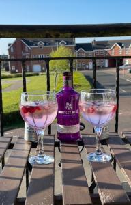 zwei Weingläser auf einem Tisch in der Unterkunft Luxury Portrush Holiday Homes - The Green, Portrush Sleeps 12 - 5 bedrooms in Portrush