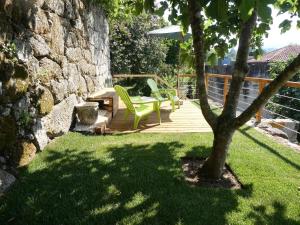 d'une terrasse avec une table, des chaises et un arbre. dans l'établissement Casa do Ribeirinho, à Amarante