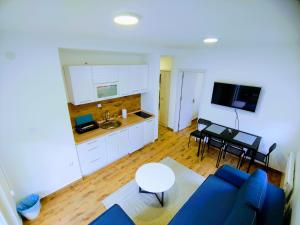a living room with a blue couch and a kitchen at MK Zlatibor in Zlatibor