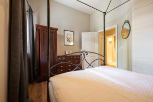 a bedroom with a white bed with a metal canopy at Haus Ludwig Murmeltier in Garmisch-Partenkirchen