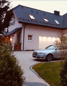 a car parked in front of a white house at Bursztynowa komnata - apartament in Gdańsk