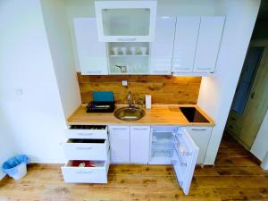 a small kitchen with white cabinets and a sink at MK Zlatibor in Zlatibor