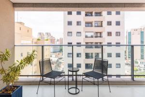 a balcony with chairs and a table on a building at Apartamento com vaga Itaim Bibi in Sao Paulo