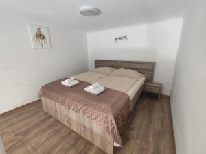 1 dormitorio con 1 cama con 2 toallas en Kossuth Garden, en Debrecen