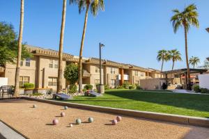 a building with palm trees and a volley ball court at WorldMark Scottsdale in Scottsdale