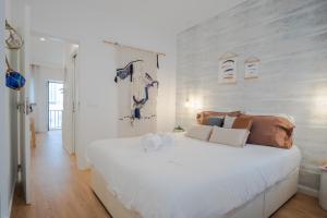 1 dormitorio con 1 cama blanca grande con almohadas en Feel Nazaré - Boutique Apartments, en Nazaré